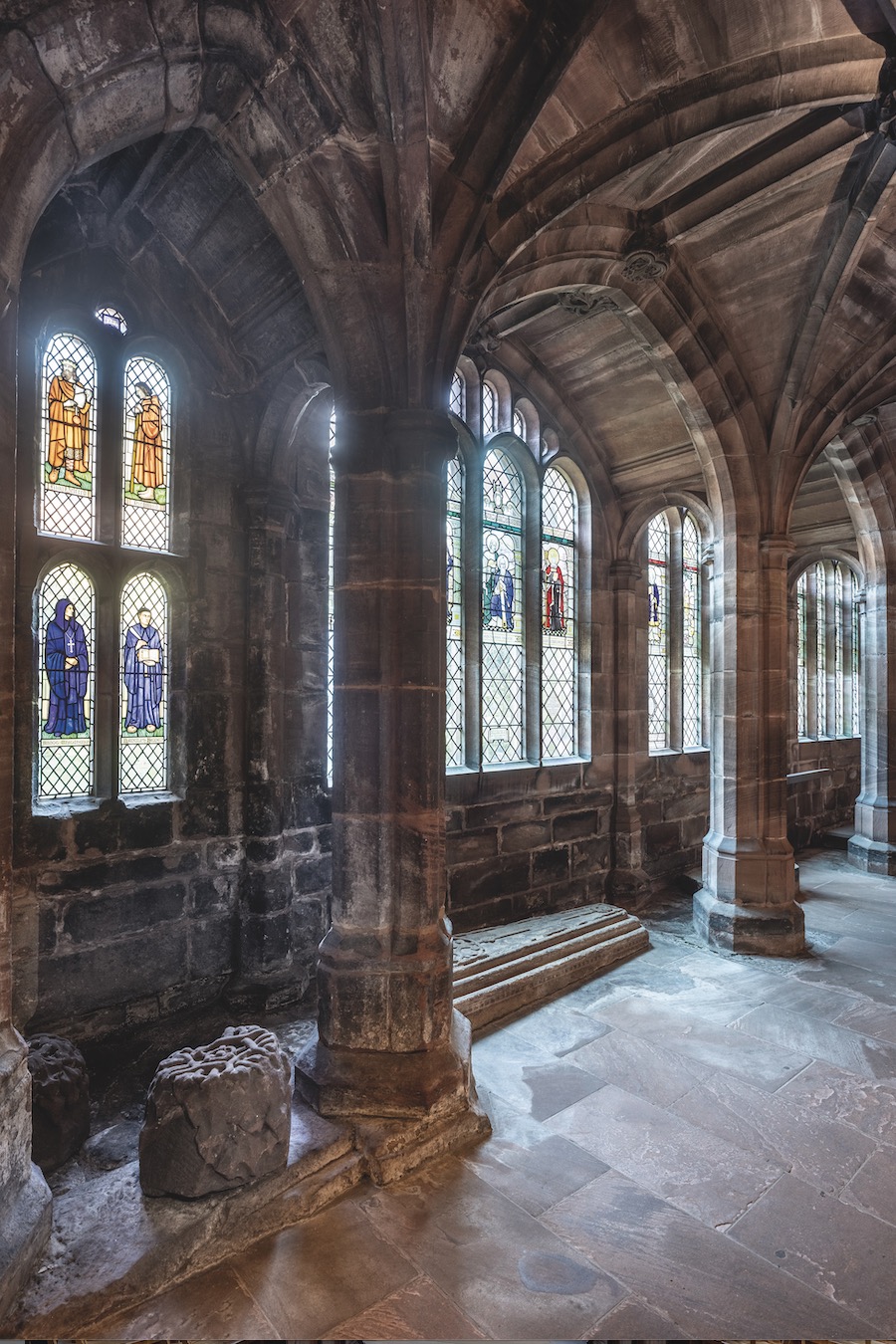 Thirty-four windows with 130 lights, presented as an Anglican calendar, most from the studio of F.C. Eden (1864–1944) and A.K. Nicholson (1871–1937), alongside designs by Chester artist Trena Cox (1895–1980), cloister window 2.4 × 0.4 m